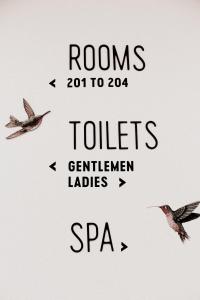 two birds flying in the sky with the words rooms to toilets gentlemen ladies at 2060 The Newton Hostel in Madrid
