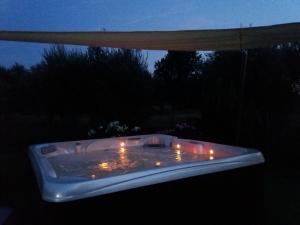 una bañera de hidromasaje en la oscuridad con velas dentro en Appartamenti Gli Ulivi Di Maremma, en Gavorrano