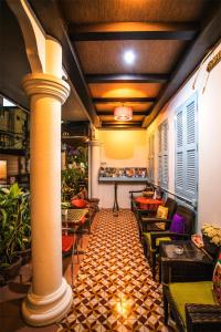 a room with chairs and tables and a column at Sino House Patong in Patong Beach