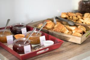 uma mesa com duas bandejas de pastelaria e frascos de mel em Hotel Le Coudon em La Farlède