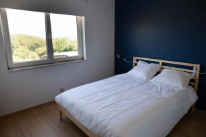 - une chambre avec un lit blanc et une fenêtre dans l'établissement le pré du poney, à Spa