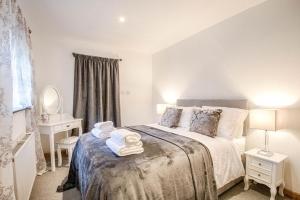 Highgate Annexe في Takeley: غرفة نوم عليها سرير وفوط