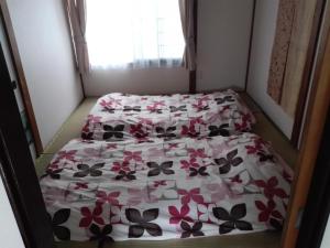 a small bedroom with two beds with flowers on it at Corpo Marika A in Hakodate