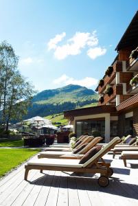eine Gruppe von Liegestühlen auf einer Terrasse in der Unterkunft Hotel Berghof in Lech am Arlberg