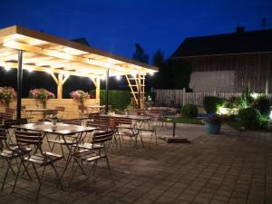 a group of tables and chairs under a pavilion at night at Landgasthof Wangerstuben in Oberostendorf