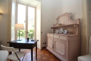 Zimmer mit einem Schreibtisch, einem Tisch und einem Fenster in der Unterkunft Casa Elide Centro Storico in Tropea