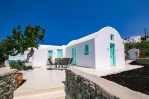 Cette maison blanche dispose de portes bleues et d'une terrasse. dans l'établissement Mulberry Villa, à Oia