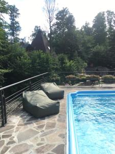 una piscina con 2 pufs en un patio en Davir Spa Resort, en Lumshory