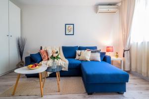 Sofá azul en la sala de estar con mesa en Urban Garden, en Sofía