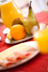 a plate of fruit on a table with a pitcher of juice at Château de la Verie in Challans