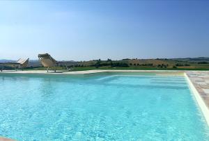 una piscina con silla y agua azul en Il Casale Dorato, en Filottrano