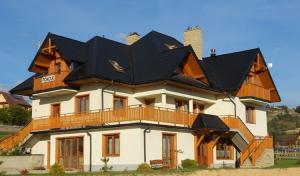 uma casa grande com um telhado preto em Willa Jaroszówka em Kluszkowce