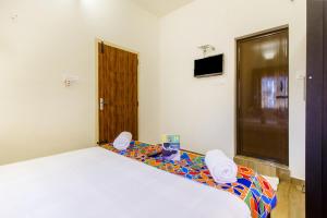 a bedroom with a white bed and a television at FabExpress Grand Castle Hill Resorts Ooty Boat House in Ooty