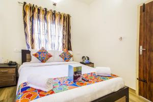 a bedroom with a large bed with a window at FabExpress Grand Castle Hill Resorts Ooty Boat House in Ooty