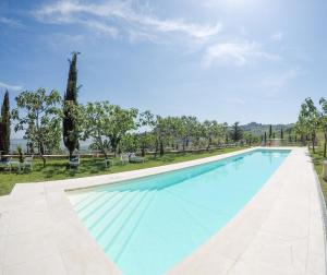 a large swimming pool with blue water at Podere Perelli in Castiglione dʼOrcia