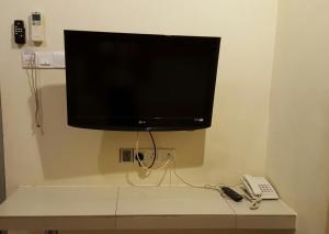 a flat screen tv on a wall with a telephone at Hotel Seri Nilai in Nilai