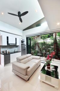 a living room with a white couch and a kitchen at Villa Labaron in Koh Samui 