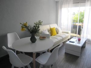 a living room with a white couch and a table and chairs at APPARTEMENT DUPLEX 71 m2 - 4 personnes in La Grande Motte +29 photos