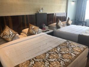 - une chambre d'hôtel avec 2 lits et des oreillers dans l'établissement Hotel Holiday Resort, à Purî
