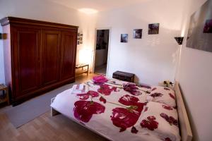 a bedroom with a bed with red roses on it at Maison Toulousaine avec jardin in Toulouse