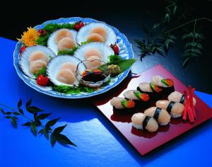 two plates of food on a table with sushi at PittINN in Goshogawara