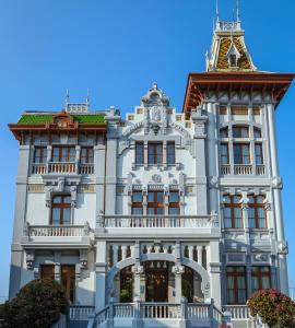a large building with a clock on the front of it at Hotel Villa Rosario in Ribadesella