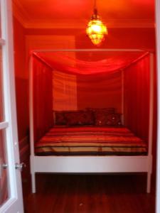 a bed room with a red and white bedspread at Porto Riad - Guest House in Porto