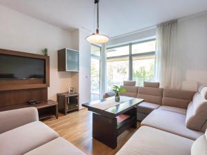 a living room with a couch and a tv at VacationClub - Diune Apartment 12 in Kołobrzeg