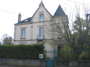 een wit huis met een hek ervoor bij Appartement agréable 1 à 4 personnes in Chaumont