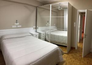 a bedroom with two beds and a large mirror at Apartments soho, Malaga center in Málaga +15 photos