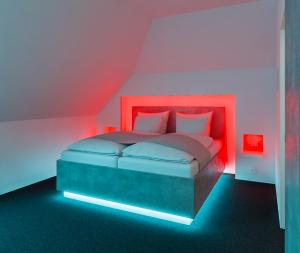 a bedroom with a bed with red and blue lights at smartel at The Unbrexit in Ahaus