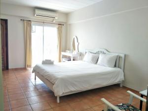 a bedroom with a white bed and a window at Lomsabai Apartments in Bangsaen