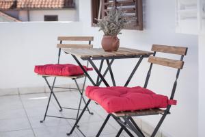 a table with two chairs and a table with red cushions at Central, spacious, great view in Hvar
