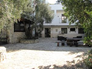 a building with a tree and benches in front of it at Mafrolla Carlo in Vieste