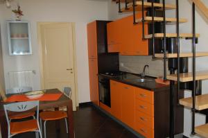 een keuken met oranje kasten, een tafel en een wastafel bij B&B Al cortiletto Modica centro in Modica