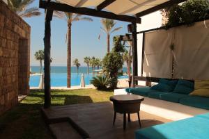 a patio with a couch and a view of the ocean at Pangea Beach Resort in Jiyeh