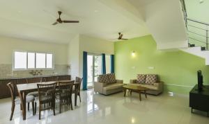 a kitchen and living room with a table and chairs at Treebo Trend Laa Gardenia Resort Yelagiri in Yelagiri