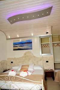 una camera da letto con un letto con una luce viola sul soffitto di Tenuta Paifer a Otranto