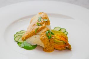 un plato blanco con un trozo de pescado y verduras en Dunbrody Country House Hotel en Arthurstown