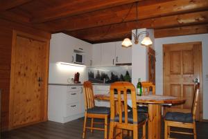 a kitchen with a wooden table and chairs at Ferienwohnungen Anderlbauer in Lofer