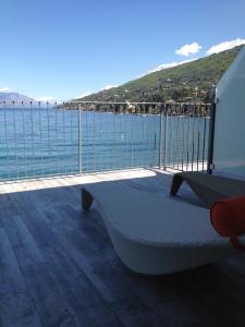 einen Balkon mit einer Bank und Meerblick in der Unterkunft Hotel Baia dei Pini in Torri del Benaco