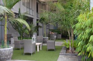 スワコプムントにあるBe-Still Accommodationの椅子と木々のあるホテルの中庭