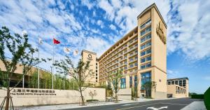 um edifício com bandeiras na lateral em The Qube Hotel Shanghai Sanjiagang - Offer Pudong International Airport and Disney shuttle em Xangai