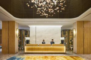 Dois homens numa recepção no átrio. em The Qube Hotel Shanghai Sanjiagang - Offer Pudong International Airport and Disney shuttle em Xangai