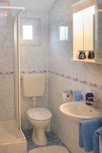 a white bathroom with a toilet and a sink at Bed and Breakfast Ritoša in Poreč