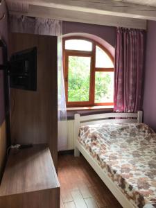 a bedroom with a bed and a window at Cottage Shchaslyvyi in Yaremche