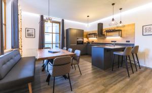 Kitz Residenz by Alpin Rentals - 8 Apartments في كابرون: مطبخ وغرفة معيشة مع طاولة وكراسي