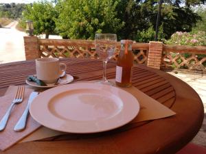 a wooden table with a plate and a wine glass at Mas Trucafort - Adults only in Falset