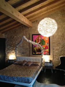 a bedroom with a large bed and a chandelier at Hotel Baia dei Pini in Torri del Benaco