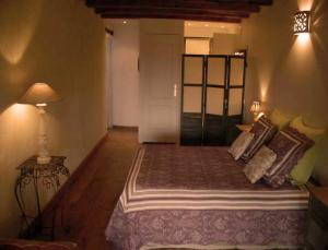 1 dormitorio con 1 cama con almohadas y lámpara en La Grange aux Loirs B&B, en Courtioux